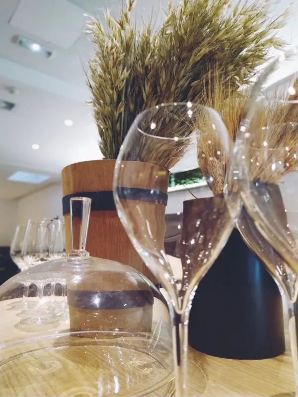 Elegant wine glasses and dried wheat arrangements on wooden table in upscale restaurant dining room