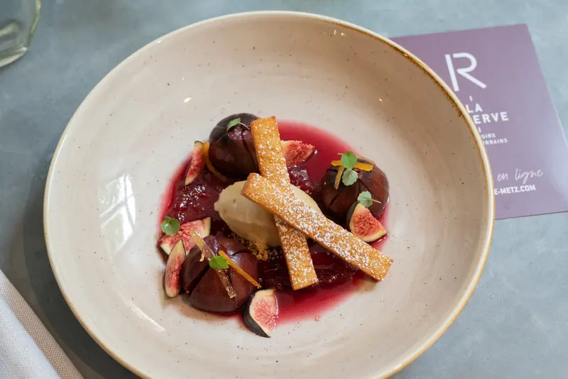 Fig dessert with poached plums, sorbet, crispy tuile, and red coulis at La Réserve Metz restaurant.